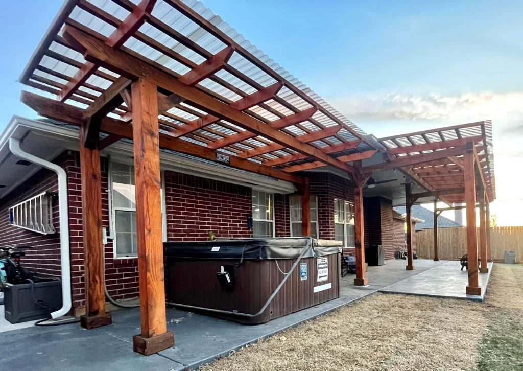 Brick patio wall and outdoor living area under a wood pergola